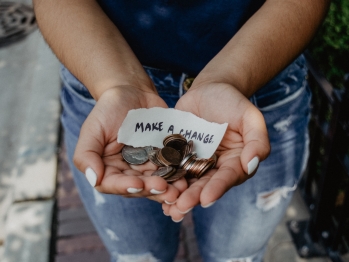 Person showing both hands with make a change note and coins