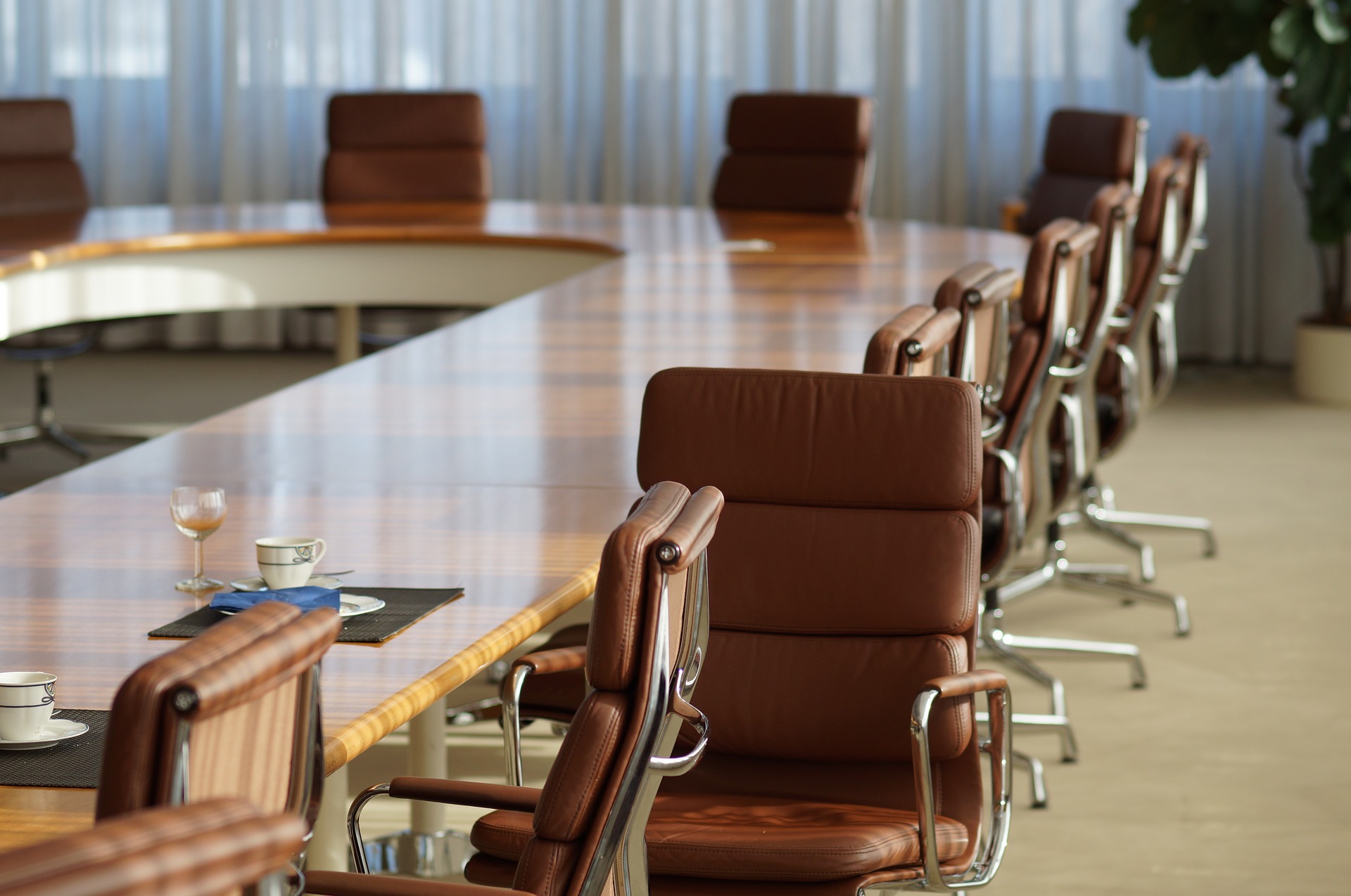 Board room style table with chairs around it, one turned toward the camera