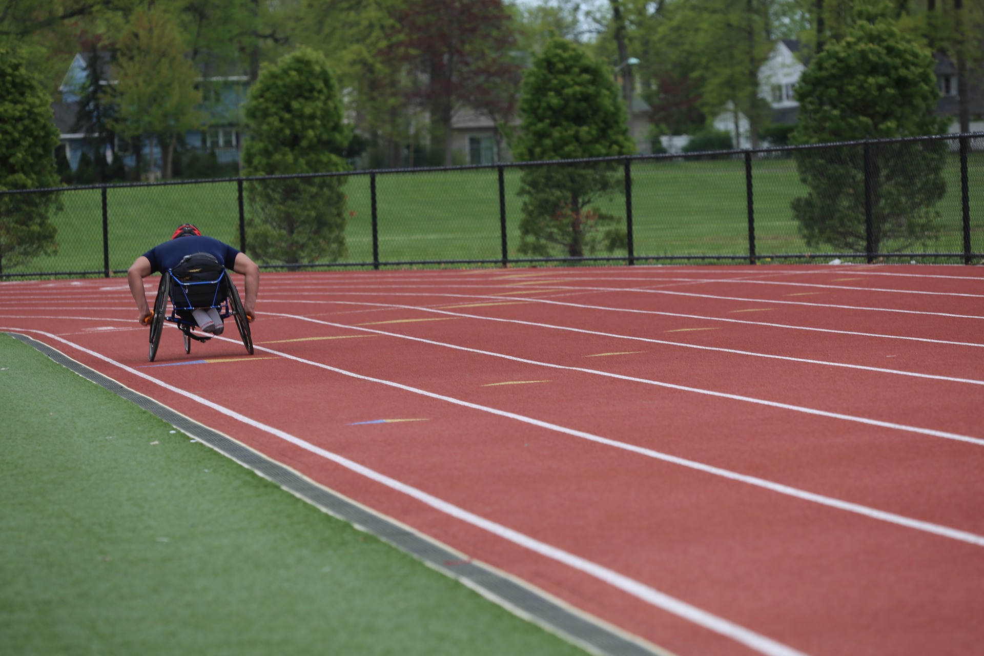 Person in wheelchair racing around track.